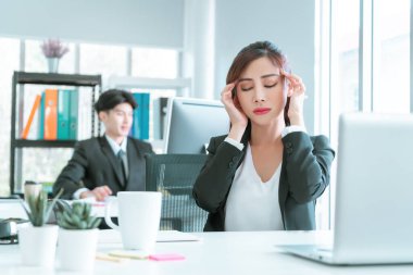 Kadın memur, ofisteki bilgisayar dizüstü bilgisayarında, ofis sendromu konseptinde çalıştıktan sonra migren ağrısı çekiyor..