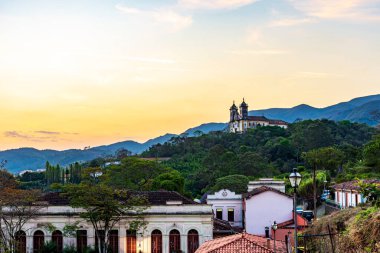 Tepedeki eski kilise. Ouro Preto şehri. Gün batımında tepeler ve bitkiler.