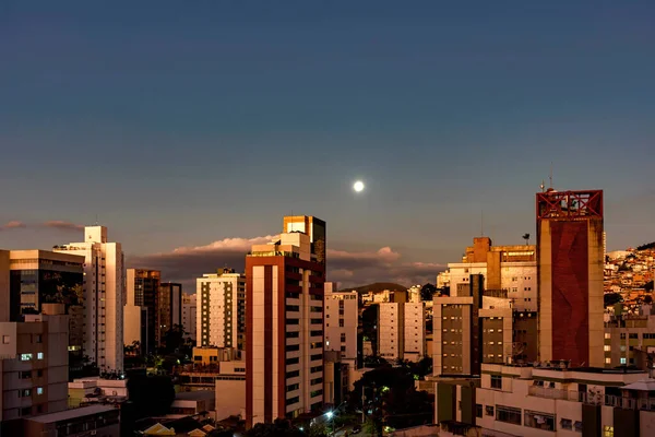 City of Belo Horizonte in the southeastern region of Brazil seen at dusk with the full moon over the buildings,