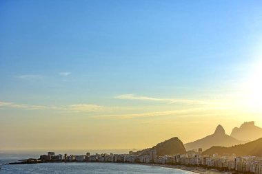 Copacabana Sahili, binaları ve Rio de Janeiro dağları yaz günbatımında yukarıdan görüldü.