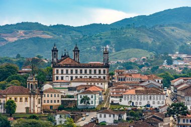 Minas Gerais 'deki tarihi Ouro Preto şehrinin arka planda sömürge tarzı evleri, kiliseleri ve dağlarıyla manzarası
