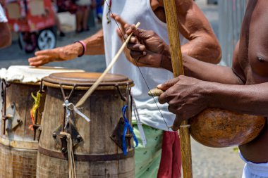 Berimbau adı verilen Brezilya enstrümanları ve atabak genellikle Afrika 'dan getirilen capoeira dövüşü sırasında kullanılır ve Salvador, Bahia' daki Pelourinho sokaklarında köleler tarafından modifiye edilir.
