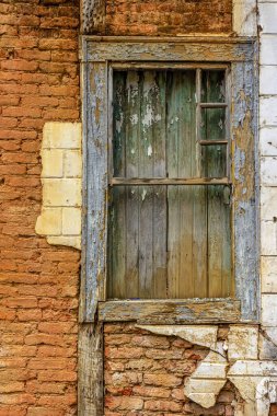 Minas Gerais 'in tarihi şehri Diamantina' da terk edilmiş bir evin ön cephesinde zaman tarafından yıkılmış eski ahşap pencere.