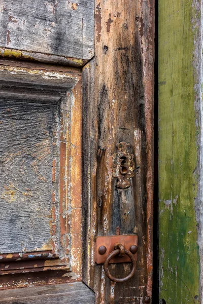 Detail of antique wooden door and lock deteriorated by time and rust in a colonial style house in the historic city of Diamantina in Minas Gerais