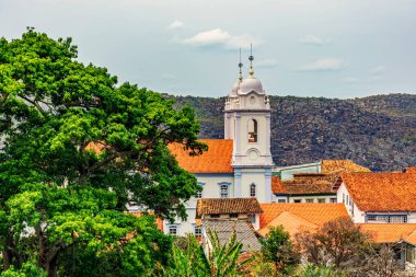 Minas Gerais 'deki tarihi Diamantina şehrinin katedralinin kuleleri çatı ustaları arasında ve arka planda dağlarla