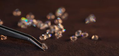 Cımbız ve büyüteçle elmas. Yere yansıyor. Cımbızla tutulan parlak kesilmiş elmas. Gemstone Güzelliği.