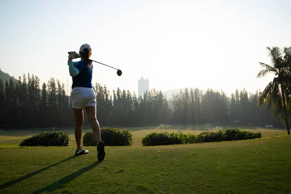 若い女性は運転範囲に彼女のゴルフ振動を練習します 後ろからのビュー スポーツコンセプト — ストック写真