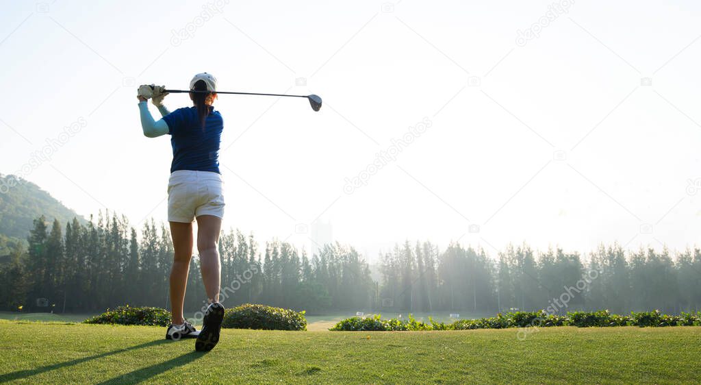 Young woman practices her golf swing on driving range, view from behind.Sport Concept