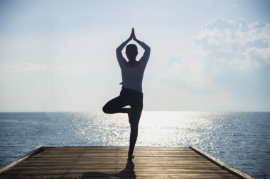 Yoga siluet. Muhteşem gün batımı sırasında okyanus üzerinde meditasyon kadın. Fitness ve sağlıklı yaşam tarzı.