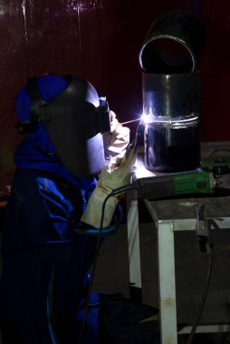 Boru hattı inşaatında kaynak yapan fabrikadaki endüstriyel işçiler.