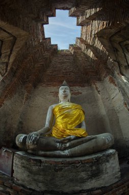 Wat Prasat Nakhon Luang veya Ayutthaya vilayetindeki Nakhon Luang Sarayı 'nda mavi gökyüzü olan eski harabeler ve Buda heykeli.