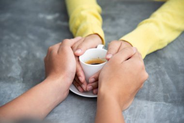 Kafede kahve bardaklarını tokuşturan çiftler.