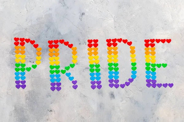 A palavra orgulho de corações pequenos nas cores da bandeira da comunidade LGBT — Fotografia de Stock