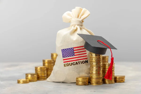 Bildung in den USA. Konzept für teure Ausbildung in Amerika. Taschen mit einem Ofen von Goldmünzen mit einer Absolventenmütze — Stockfoto