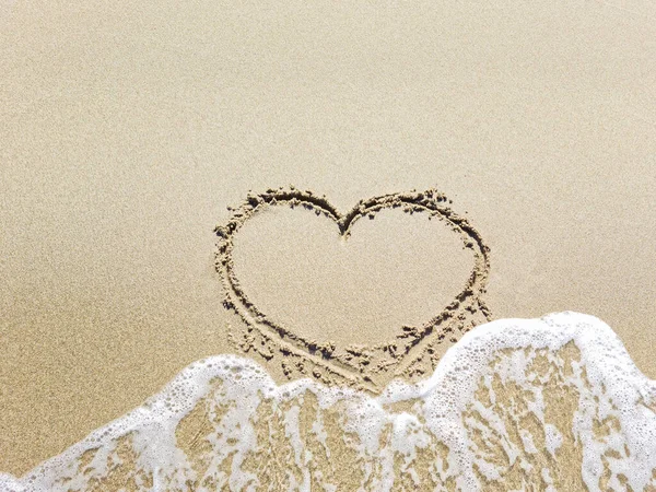 Het hart in het zand wordt weggespoeld door de zee golf. Uitgaand liefdesconcept — Stockfoto