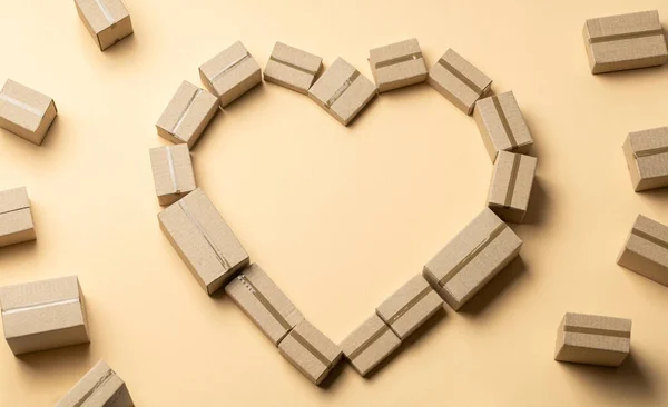 Symbol srdce vyrobený z lepenkových krabic na hnědém pozadí. Oblíbená společnost dodávající koncepci — Stock fotografie