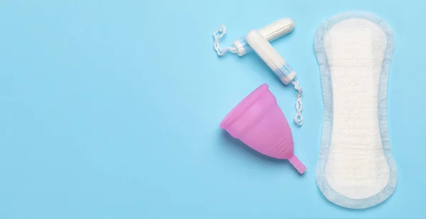 Higiene durante a menstruação. Almofada e tampões com copo menstrual em um fundo azul — Fotografia de Stock