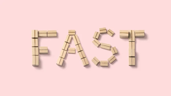 「 FAST 」という言葉はピンクの背景の段ボール箱から作られています — ストック写真