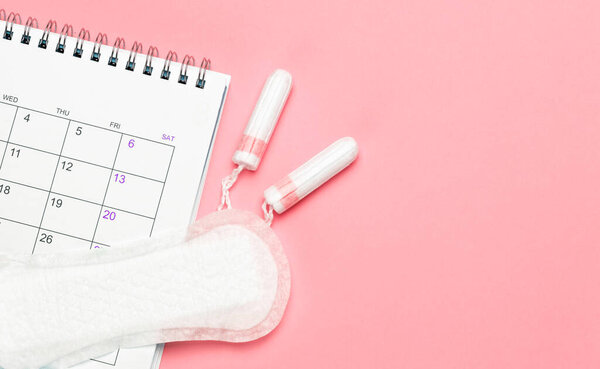 Менструационный календарь. Календарь с прокладками и тампонами на красном фоне. Шаблон Копирование пространства для текста. mock-up