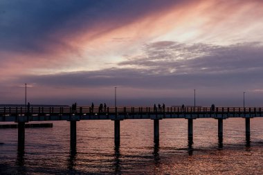 Leylak gün batımı denizin üzerinde, gezinti güvertesinde, iskelede