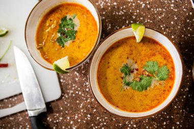 Masadaki kilden bir kasede Asya usulü sıcak kırmızı çorba.