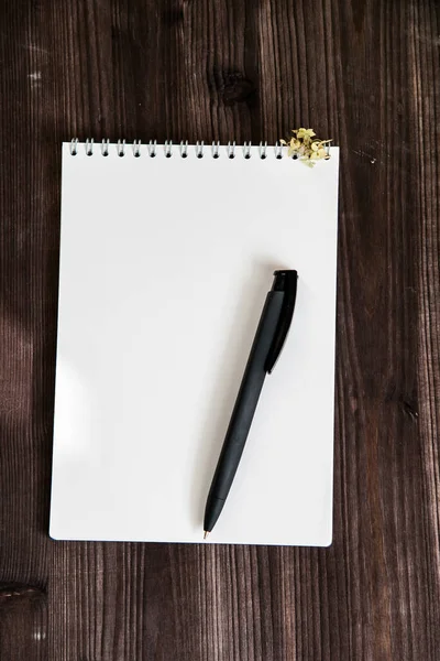  Koyu ahşap arkaplanda beyaz bir defter aç   