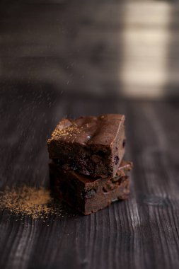 Kekin üzerine koyu bir arka planda kakao serpilmiş.