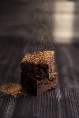 Kekin üzerine koyu bir arka planda kakao serpilmiş.