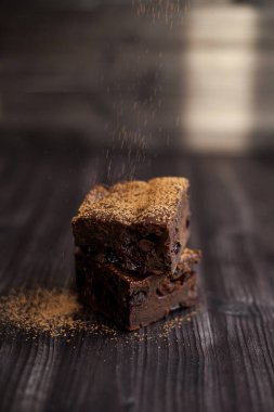 Kekin üzerine koyu bir arka planda kakao serpilmiş.