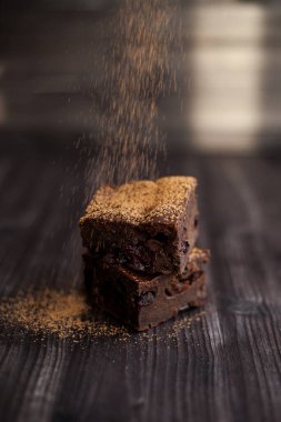 Kekin üzerine koyu bir arka planda kakao serpilmiş.