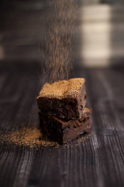 Kekin üzerine koyu bir arka planda kakao serpilmiş.