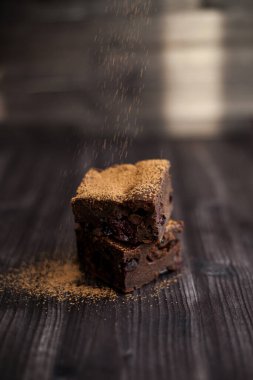 Kekin üzerine koyu bir arka planda kakao serpilmiş.