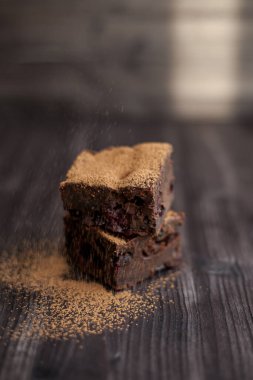 Kekin üzerine koyu bir arka planda kakao serpilmiş.