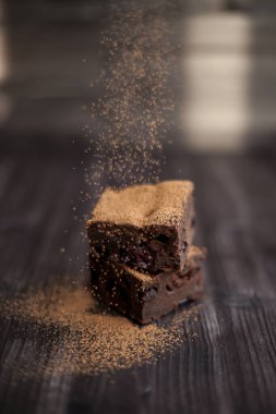 Kekin üzerine koyu bir arka planda kakao serpilmiş.