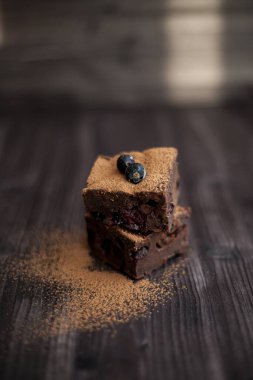 Koyu arkaplanda taze böğürtlenlerle süslenmiş kek.