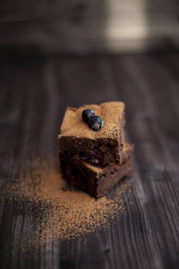 Koyu arkaplanda taze böğürtlenlerle süslenmiş kek.