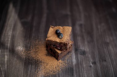 Koyu arkaplanda taze böğürtlenlerle süslenmiş kek.