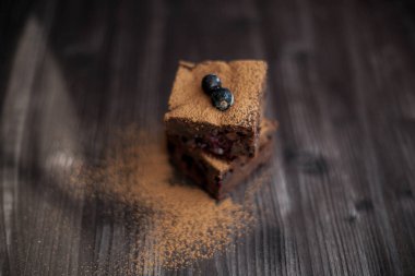 Koyu arkaplanda taze böğürtlenlerle süslenmiş kek.