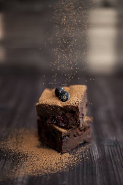 Koyu arkaplanda taze böğürtlenlerle süslenmiş kek.