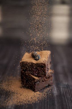 Koyu arkaplanda taze böğürtlenlerle süslenmiş kek.