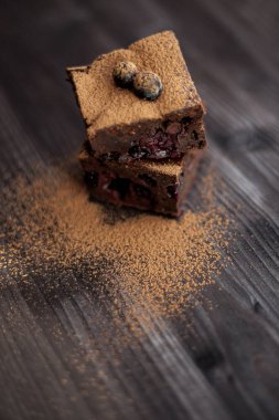 Koyu arkaplanda taze böğürtlenlerle süslenmiş kek.