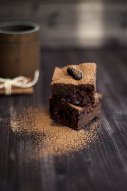 Koyu arkaplanda taze böğürtlenlerle süslenmiş kek.