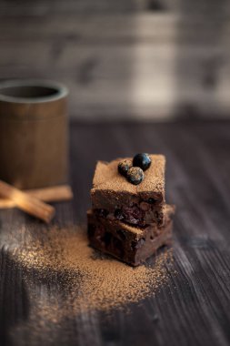 Koyu arkaplanda taze böğürtlenlerle süslenmiş kek.