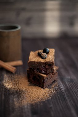 Koyu arkaplanda taze böğürtlenlerle süslenmiş kek.