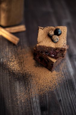 Koyu arkaplanda taze böğürtlenlerle süslenmiş kek.