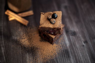 Koyu arkaplanda taze böğürtlenlerle süslenmiş kek.