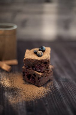 Koyu arkaplanda taze böğürtlenlerle süslenmiş kek.