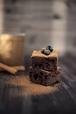 Koyu arkaplanda taze böğürtlenlerle süslenmiş kek.