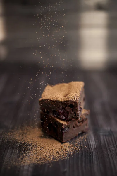 Pastel Brownie Espolvoreado Con Cacao Molido Sobre Fondo Oscuro — Foto de Stock