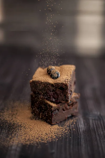 Koyu arkaplanda taze böğürtlenlerle süslenmiş kek.